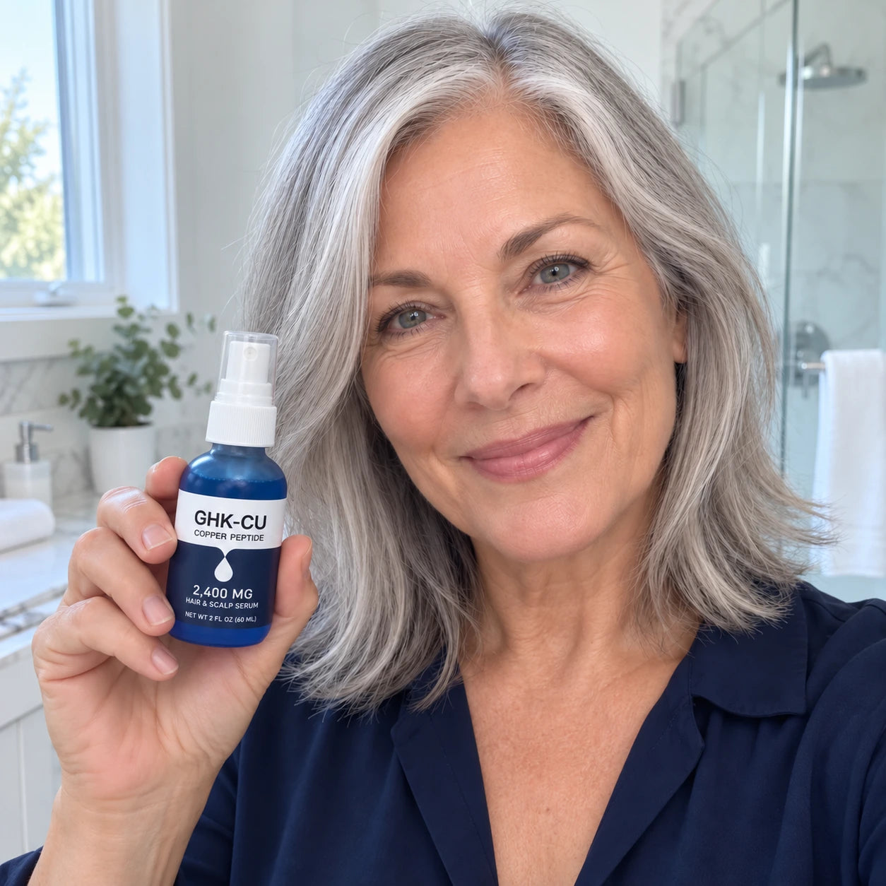 Mature woman smiling with her Nuralis GHK-Cu serum in a bathroom