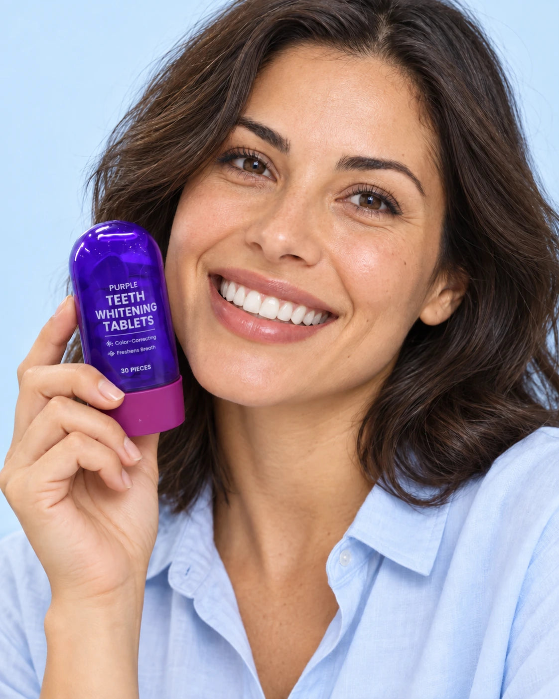 A model smiling directly at the camera while holding the current generic purple bottle