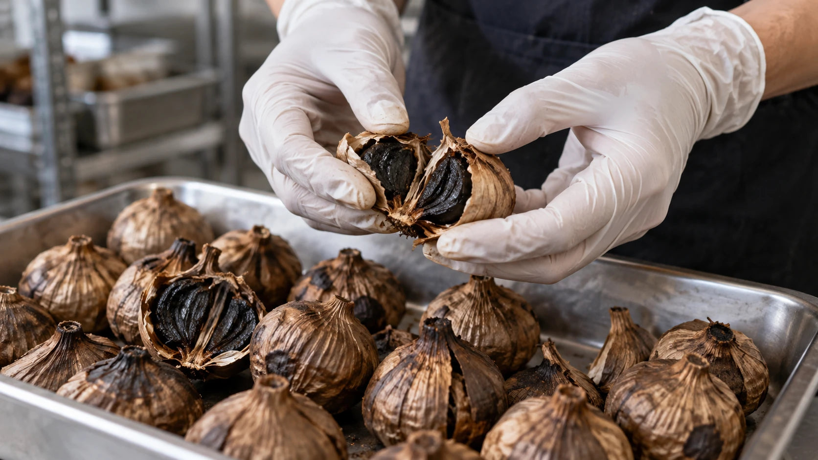 Illustrative preparation scene: opening aged black garlic over a steel tray