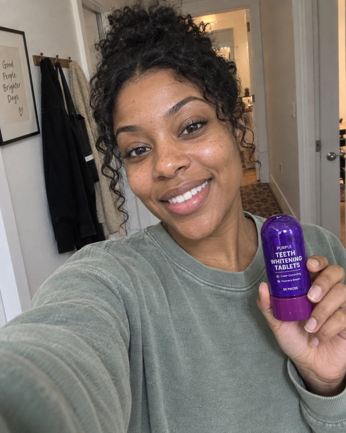 AI lifestyle image: woman taking a casual hallway selfie with the original purple bottle